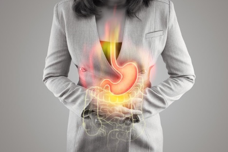 An illustration of the stomach and large intestine on the woman's body against a gray background