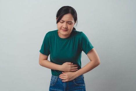 Woman putting her hands on her belly while standing to prevent diarrhea